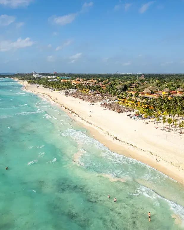 Vista aérea de la playa con palapas y hoteles en Playa del Carmen