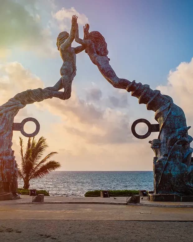 Escultura Portal Maya frente al mar al atardecer en Playa del Carmen