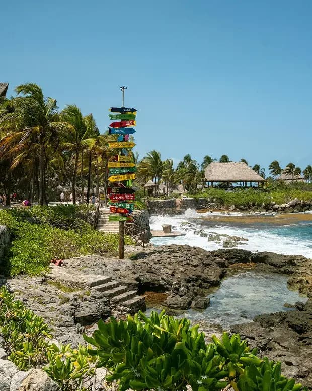 Señalización direccional junto a la costa rocosa de Playa del Carmen