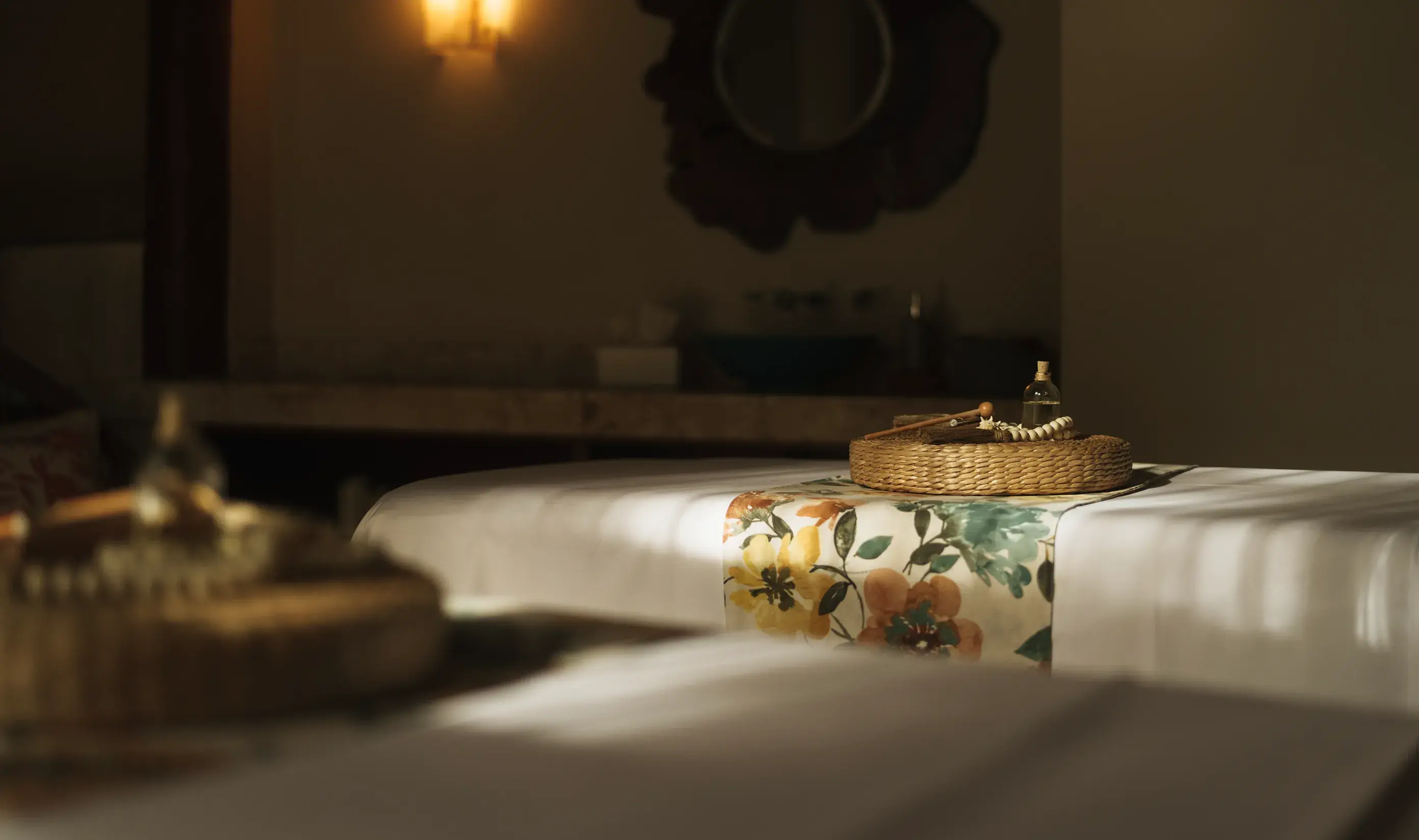 Massage table with a floral runner and aromatic oils