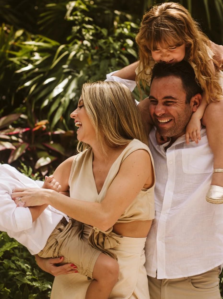 Familia sonriendo en un jardín tropical de Mahekal Beach Resort